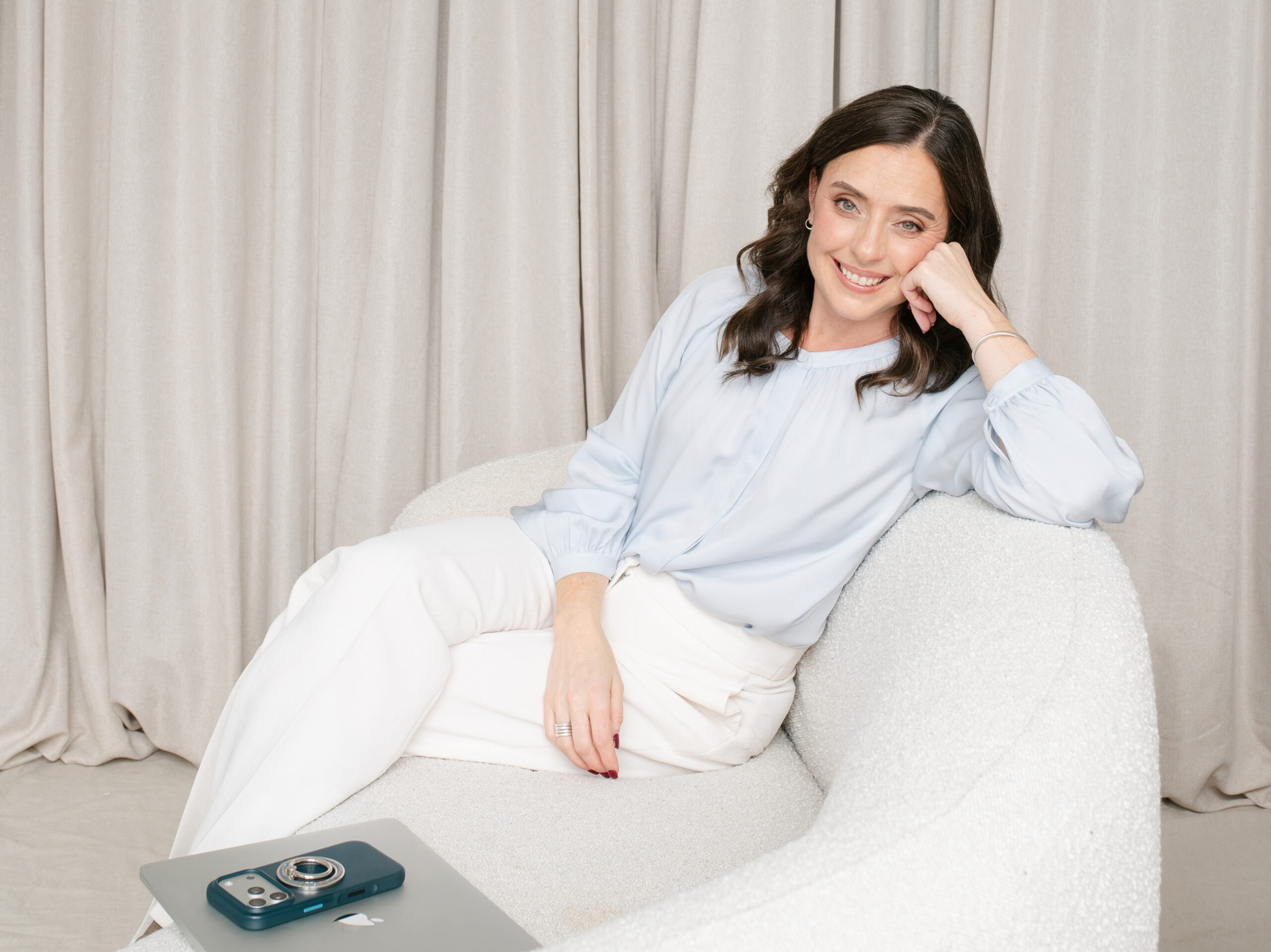 Christine Walker sitting comfortably on a white couch